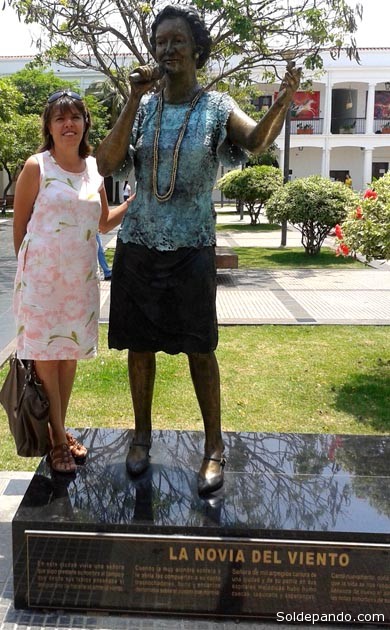 La autora del homenaje, periodista Silvia Antelo, junto al monumento de Gladys Moreno en la Manzana Uno de Santa Cruz. | Foto Sol de Pando