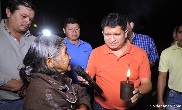 "No más mecheros" le dice el gobernador Flores a una anciana habitante de Mukden mientras se prende la luz eléctrica. | Foto Prensa GADP