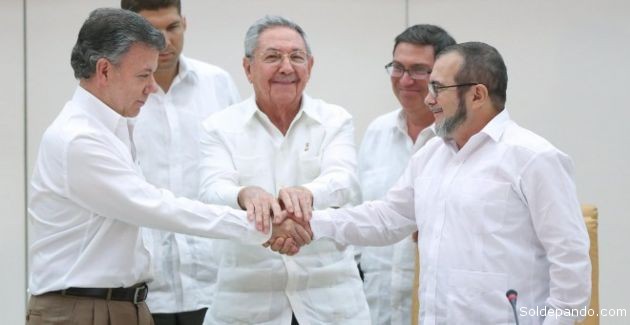 El presidente de Colombia, Juan Manuel Santos, se da la mano con el jefe de las FARC, Rodrigo Londoño 'Timochenko', en presencia del presidente de Cuba, Raúl Castro. | Foto Reuters
